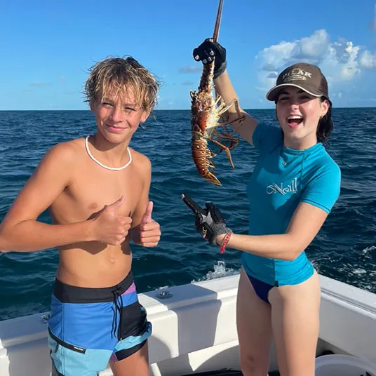 Two kids highlighting a lobster catch